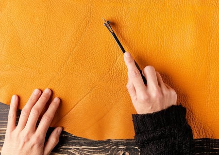 Close up hand cutting leather