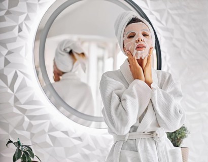 Young woman using beauty face mask