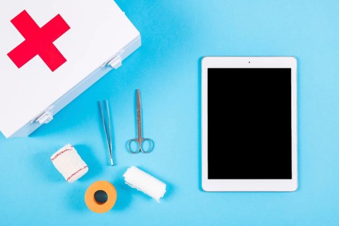 Medical equipments with first aid kit blank digital tablet blue background
