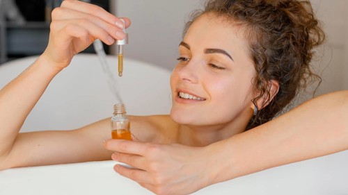 Woman relaxing bathtub with serum
