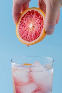 Close up man holding red orange slice