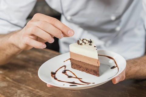 Male pastry chef decorating dessert kitchen