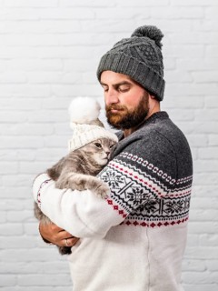 Front view man kitten wearing fur cap
