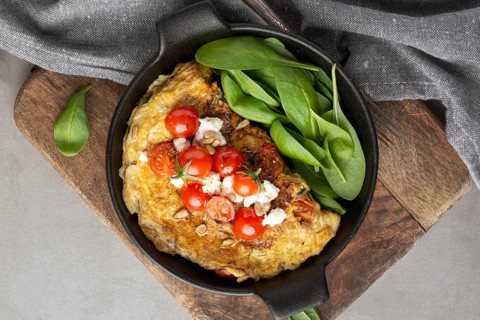 Omelette with cheese tomatoes cutting board