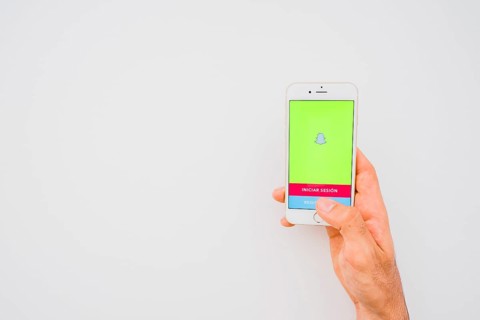 Hand holding phone with snapchat copy space