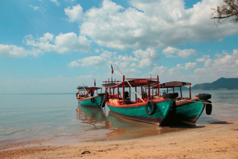 Khmer fishing boats moored at the shore of Koh Tonsay Island or Rabbit Island in Kep Cambodia