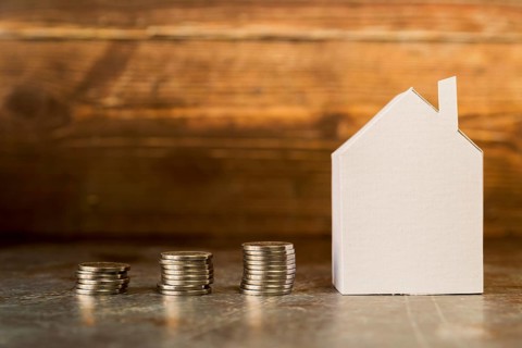 Increasing stack coins near paper house surface