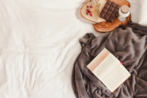 Opened book blanket near chocolate bar
