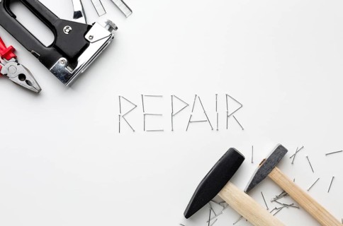 Hammers repair word written with nails