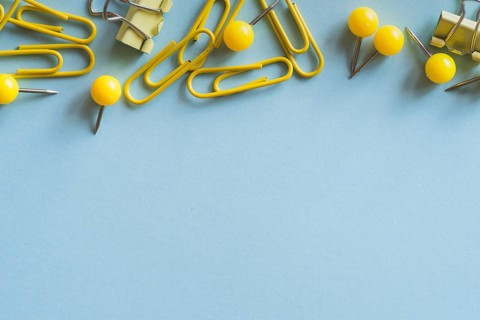 Yellow paper clips push pins binder clips