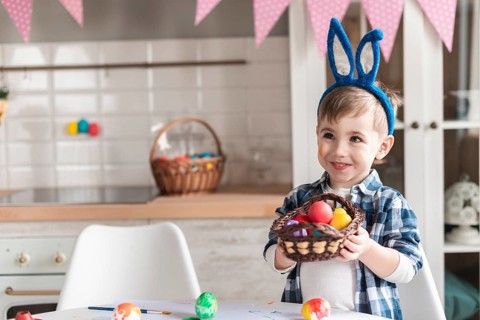 Portrait little boy holding basket with easter eggs