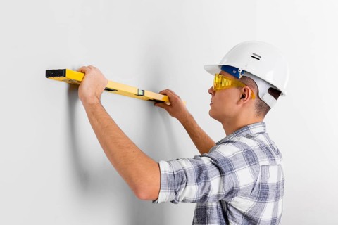 Worker with spirit level wall