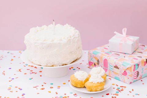 Birthday cake muffins gift boxes with confetti white desk against pink background
