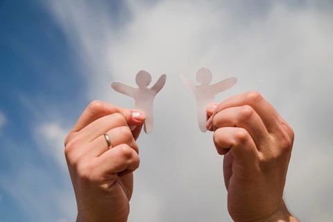 Paper men against sky