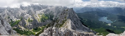 View from the summit of the Waxenstein over rocky and narrow ridge of the Waxenstein ridge to Eibsee lake and Hoellental with Jubilaeumsgrat