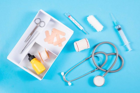 Open first aid kit with medical equipments blue background