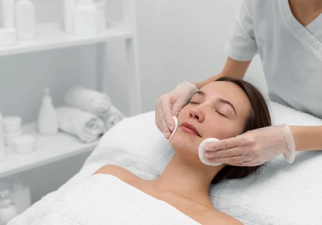 Beautician with female client salon face care routine