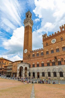 Atmospheric clouds at the Piazza del Campo with its bell tower Torre del Mangia and the town hall Palazzo Pubblico
