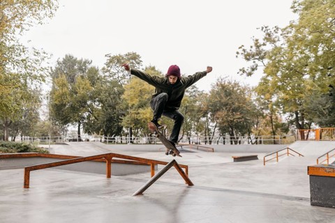 Man outside with skateboard park