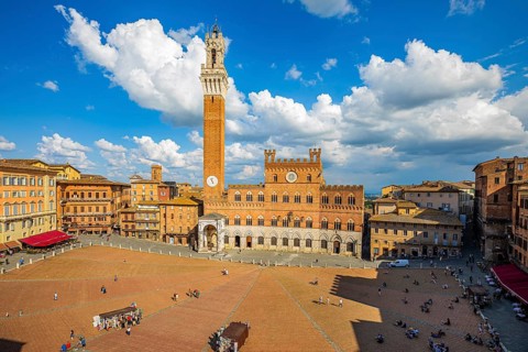 Spring clouds over the Piazza del Campo with the bell tower Torre del Mangia and the town hall Palazzo Pubblico