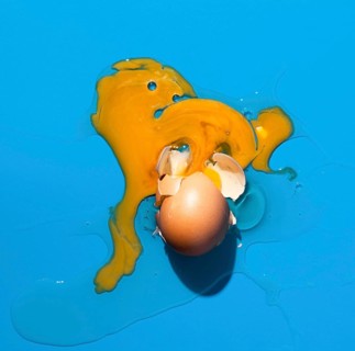 Top view broken egg blue background