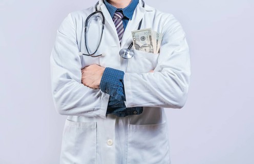 Corrupt doctor with bribe money in pocket isolated. Medical bribery concept. Bribed doctor with money in pocket isolated