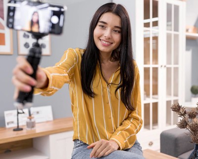 Female vlogger home with smartphone