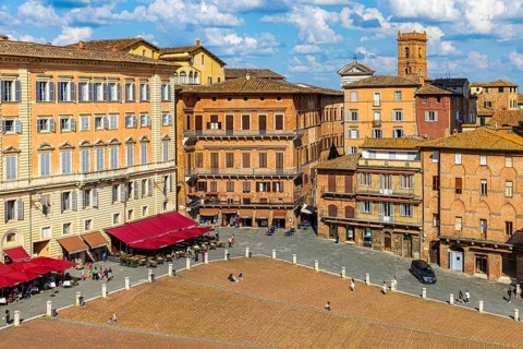 View of the Piazza del Campo with street cafes under red awnings