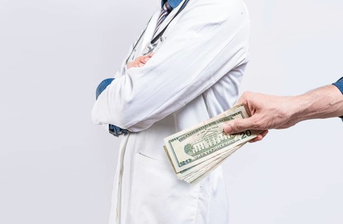 Hand of person bribing doctor. Hands putting money in doctor pocket