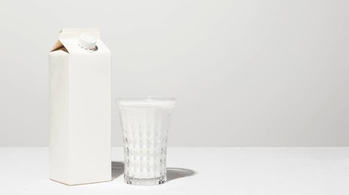 Front view milk carton with full glass copy space