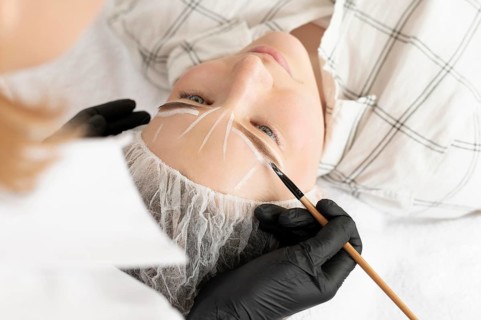 Woman getting eyebrow treatment beauty salon