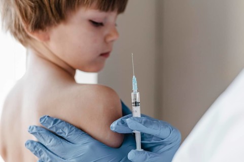 Doctor with gloves performing vaccine little child