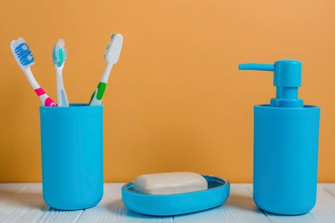 Toothbrushes soap soap dispenser bottle white desk against wall