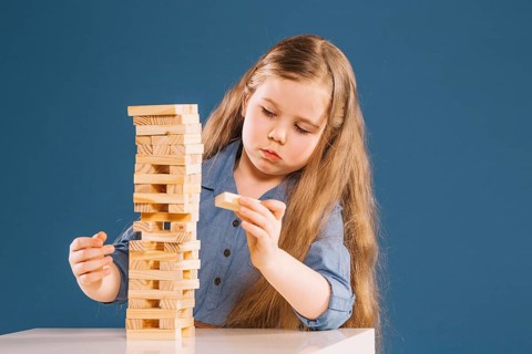 Cute girl removing blocks from jenga tower