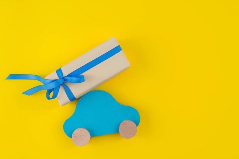 Gift box with toy car yellow table