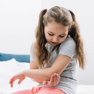 Close up girl touching her elbow with hands