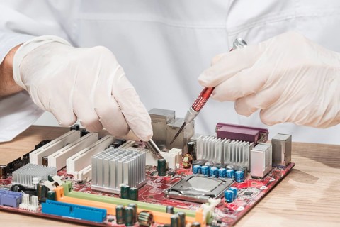 Technician wearing gloves working computer motherboard