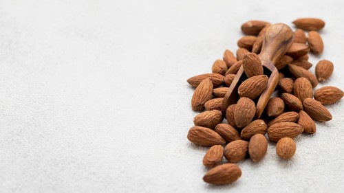 Organic almond nuts wooden spoon copy space