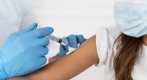 Close up male doctor vaccinating girl