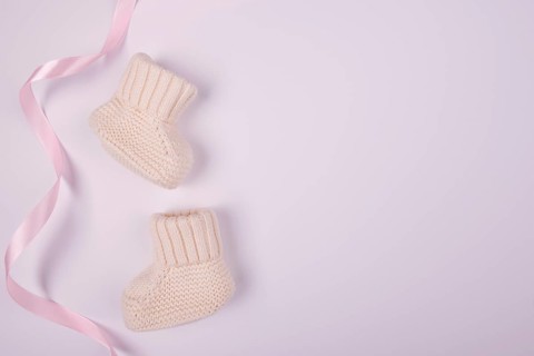 Baby socks with pink ribbon flat lay