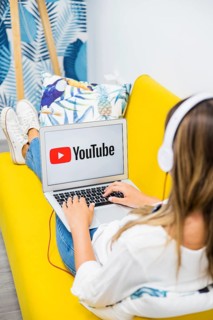 Woman with headphones watching laptop