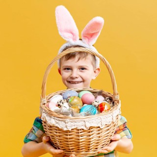 Little boy holding basket with painted eggs