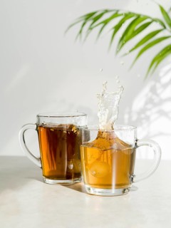 Front view tea splashing glass