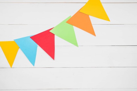 Colorful triangular bunting white wooden plank