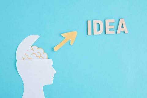 Open paper human head with yellow arrow pointing word idea blue background