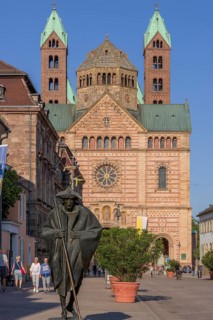 Bronze sculpture Jacob's Pilgrim by Martin Mayer and behind it The Imperial Cathedral of Speyer also called Speyer Cathedral or Cathedral Church of St Mary and St Stephen