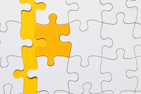 High angle view yellow puzzle piece arranged with white pieces