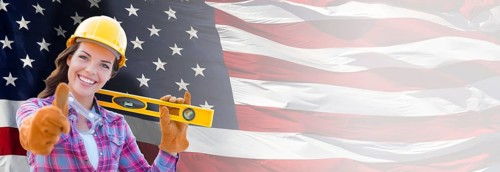 Female contractor wearing blank yellow hardhat and gloves over waving american flag background banner