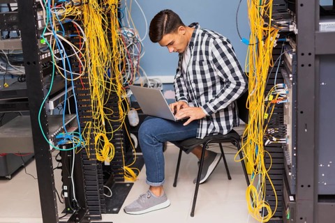 Network engineer with laptop long shot