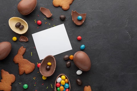 Top view chocolate easter eggs with colorful candy copy space